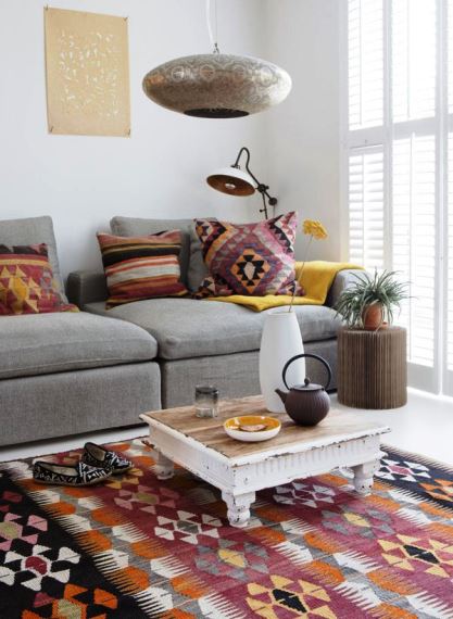 Μοντέρνος γκρι καναπές σε συνδυασμό με πολύχρωμα etnhic μαξιλάρια και ασορτί χαλί. Η mix & match διακόσμηση γίνεται ακόμη πιο φανερή με το vintage coffee table και το industrial επιδαπέδιο φωτιστικό.