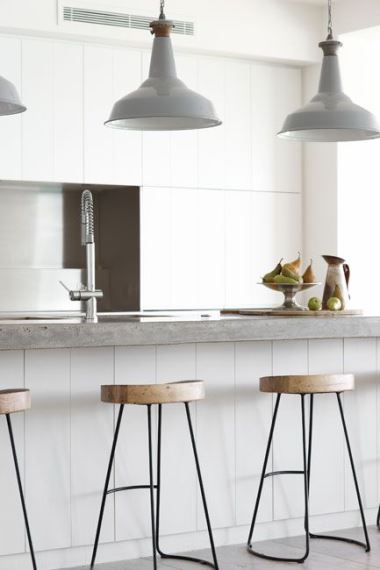 Minimal λευκή κουζίνα με σκαμπό από ξύλο και μεταλλικό σκελετό.