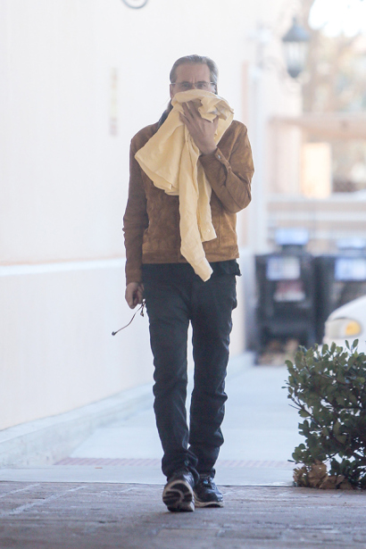 ***MANDATORY BYLINE TO READ INFphoto.com ONLY*** EXCLUSIVE: Val Kilmer, looking strikingly thin in a sweater and skinny jeans, hides his face as he drops off a mystery female companion at the healthy juice bar, Vitamin Barn, in Malibu, California, before heading to a local grocery store to stock up on food. Pictured: Val Kilmer Ref: SPL918642 281214 EXCLUSIVE Picture by: Borisio/SAA/INFphoto.com 