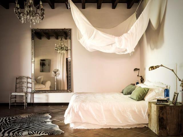 Marianne Tiegen: Ακόμα μία περίπτωση υπνοδωματίου με mix 7 match decor που «μπλέκει», το ρομαντικό με το μοντέρνο στιλ συνδυάζοντας animal print χαλί και ένα industrial φωτιστικό με vintage πολυέλαιο, αιώρα και oversized καθρέφτη.