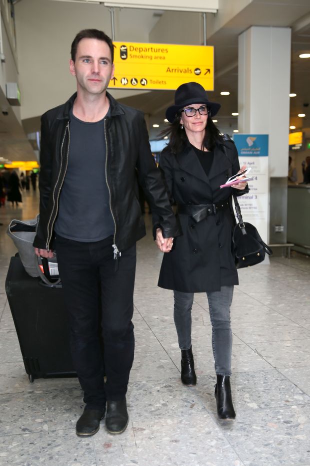 EXCLUSIVE: Courteney Cox and Johnny McDaid are back on as the pair kiss at Heathrow airport this afternoon.