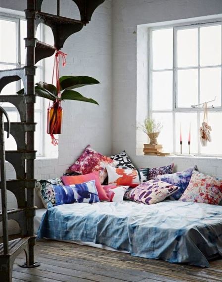 Τα πολλά μαξιλάρια χαρίζουν ένα boho χαρακτήρα. Το στρώμα στο πάτωμα παραπέμπει σε loft.