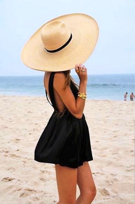Κοντό, μαύρο φόρεμα και μεγάλο, ψάθινο καπέλο.