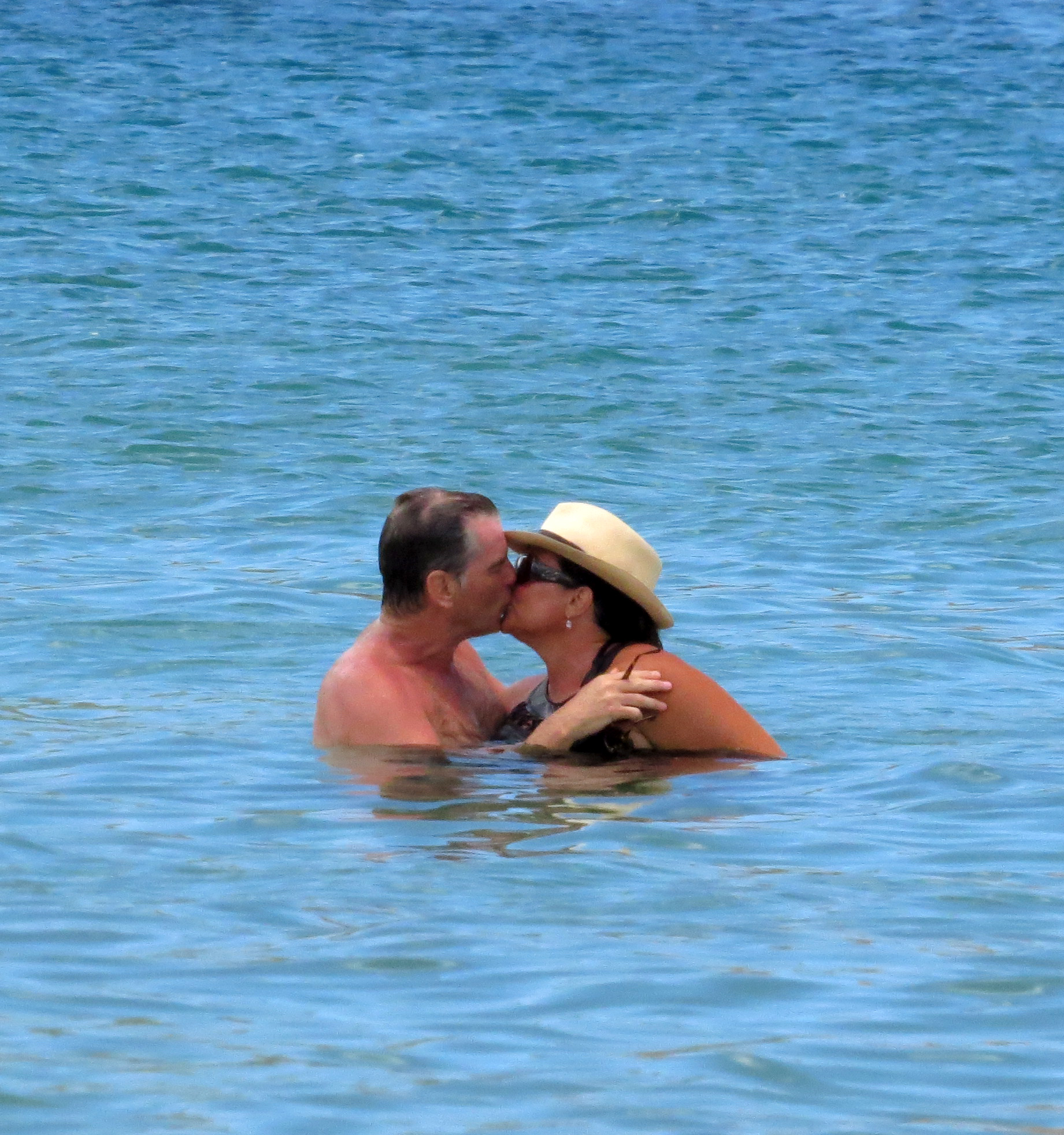 Pierce Brosnan and wife Keely Shaye Smith enjoy a kiss in the waters off Kauai
