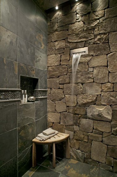 Ντουζιέρα με πέτρινο τοίχο και μαρμάρινα πλακάκια για ένα μόνιμο mini spa στο σπίτι.