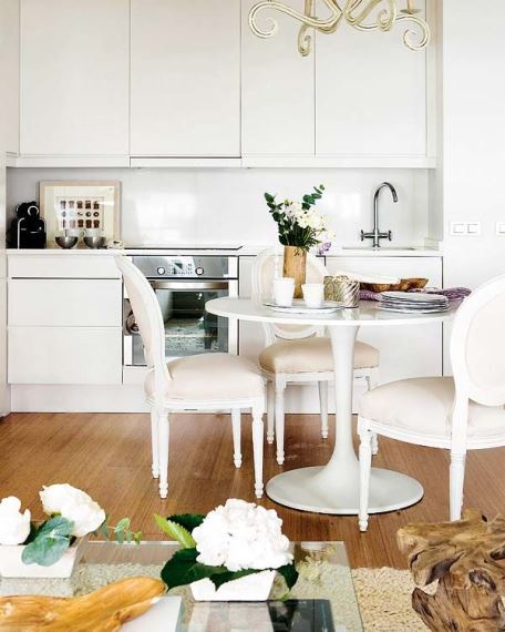Λευκή κουζίνα με mix & match decor στο τραπέζι και τις καρέκλες.