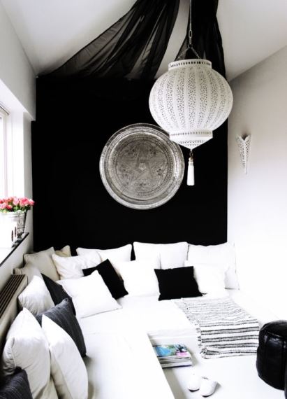Ένα μοντέρνο black & white καθιστικό αποκτά προσωπικότητα με τρεις μικρές αλλαγές: Τον μεταλλικό δίσκο στον τοίχο, το oriental φωτιστικό και οι μαύρες διάφανες κουρτίνες.