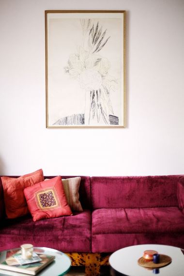 Οι βελούδινες υφές και οι βαθιές κόκκινες αποχρώσεις στον καναπέ, εκπέμπουν oriental ύφος.